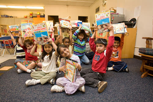 Children raise books over head